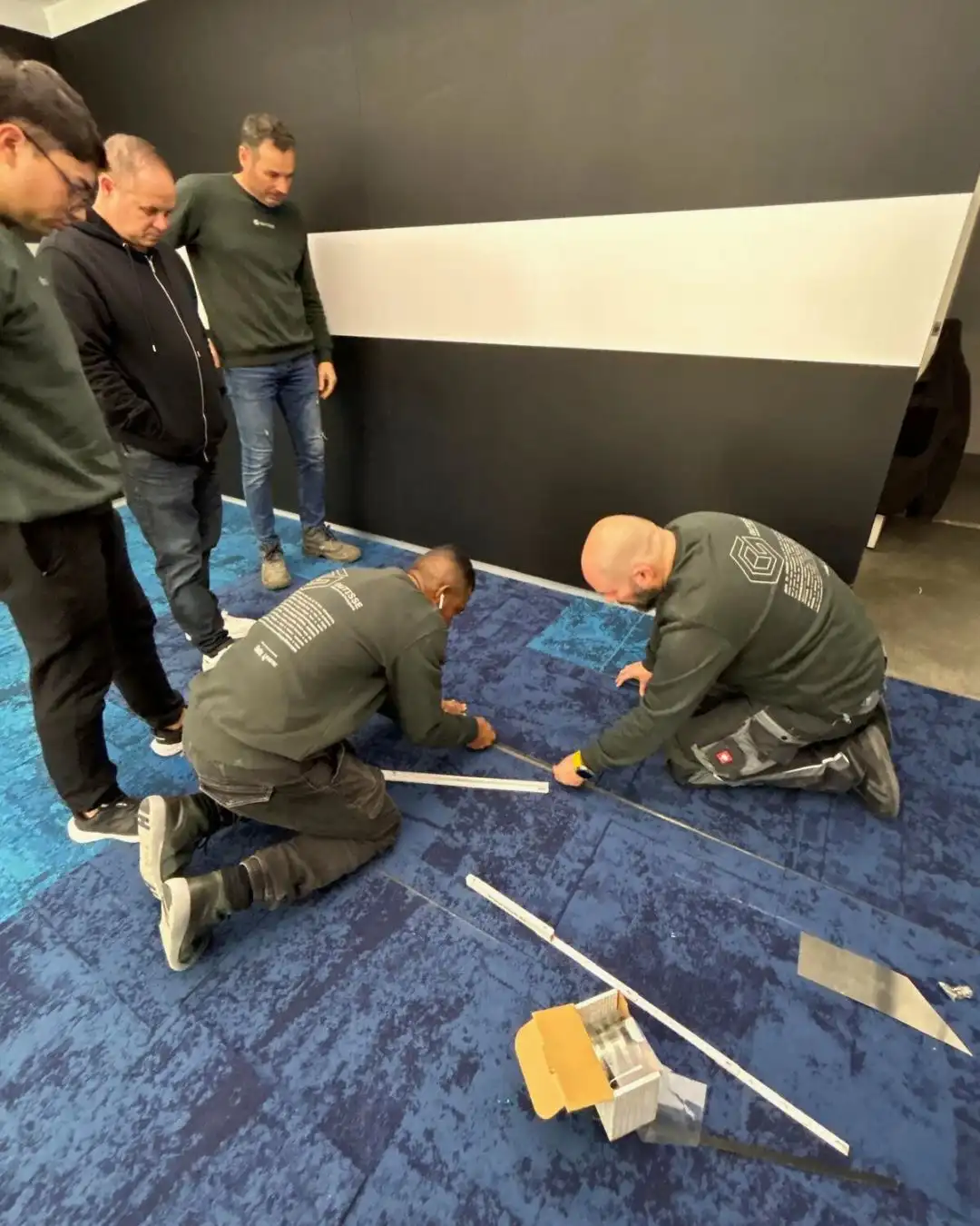 equipo de gutisse en formación de instalación de moqueta en losetas